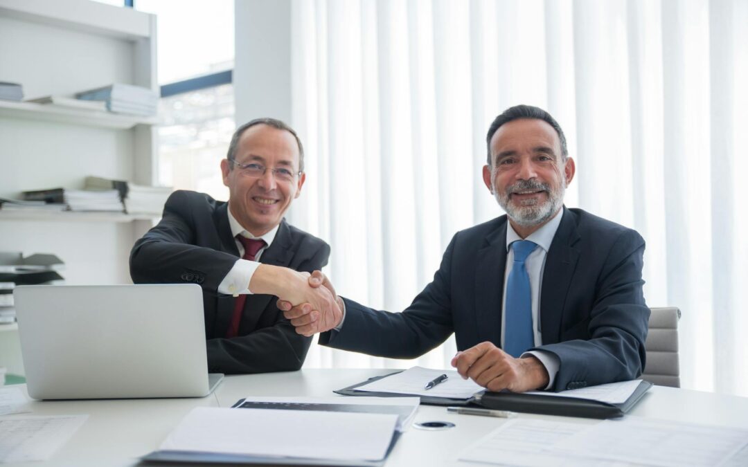 businessmen having a deal while doing handshake